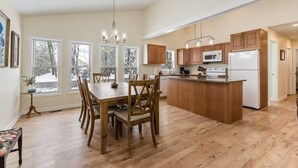A spacious kitchen with wooden cabinets, a central island, and a dining area with a large table and chairs. - Two Homes: 1-Hot Tub; 2-Lakefront w/Dock, Big Yard (Pullman)