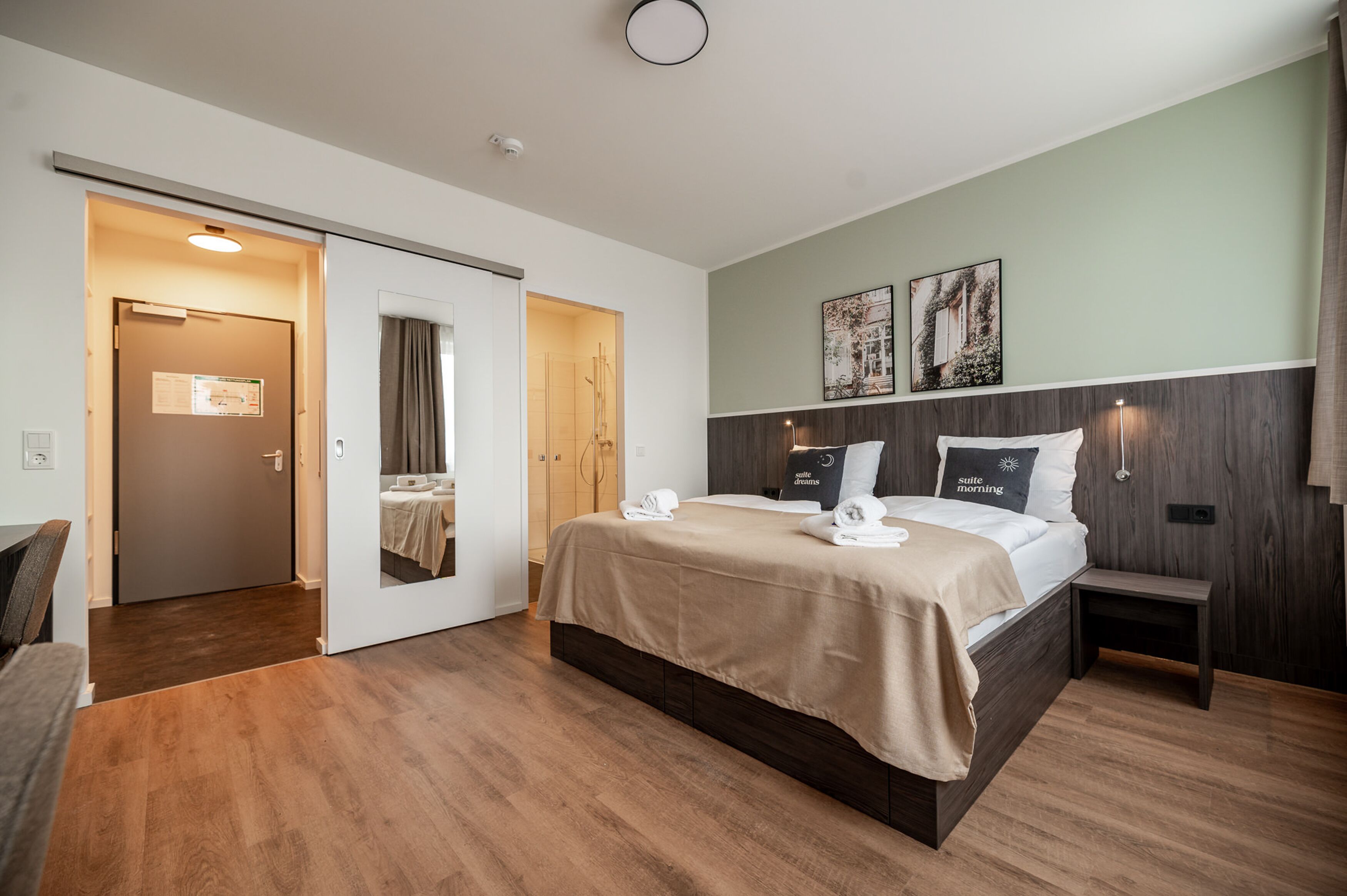 Ein Hotelzimmer mit Bett, Nachttisch und einer Tür zu einem Badezimmer.