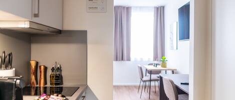 A modern kitchen with a built-in stove and a dining area with a table and chairs.