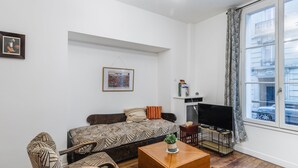 A modern living room with a sofa, a coffee table, and a TV.