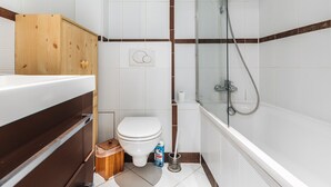 A bathroom with a shower, toilet, and sink.
