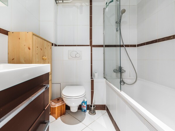 A bathroom with a shower, toilet, and sink.