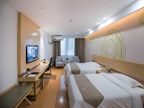 Una habitación de hotel con dos camas, un escritorio, un televisor y una zona de estar.