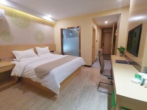 Habitación de hotel con cama, mesitas de noche, escritorio con silla, televisor y puerta que da a otra habitación.