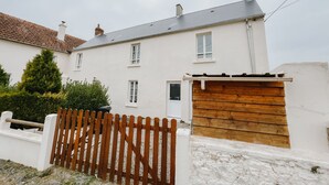 A white two-story house with a tiled roof, a wooden gate, and a white exterior wall. - cottage of the poste (Crouay)