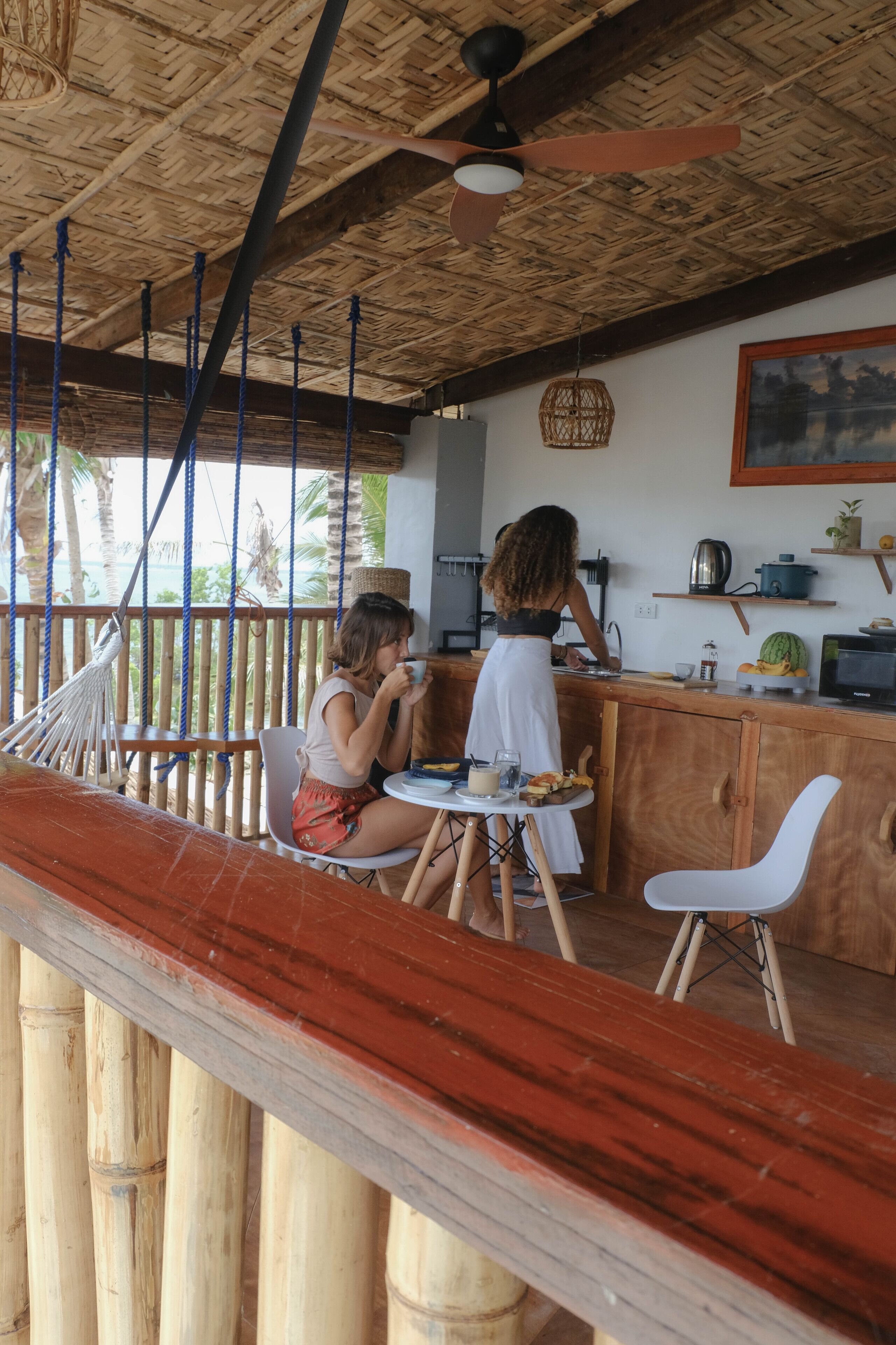 Une terrasse en bois comprenant un espace repas, un bar et un coin cuisine.
