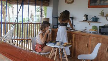 Une terrasse en bois comprenant un espace repas, un bar et un coin cuisine.