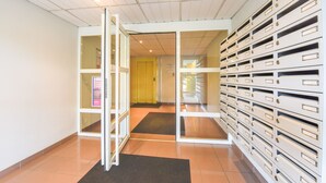 A hallway with a mailroom and a yellow door. - Résidence Columba  (Agen)