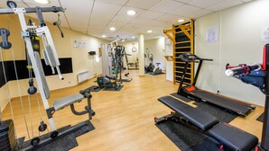 A gym with various exercise equipment, including treadmills, weight machines, and a bench. - Résidence Columba  (Agen)