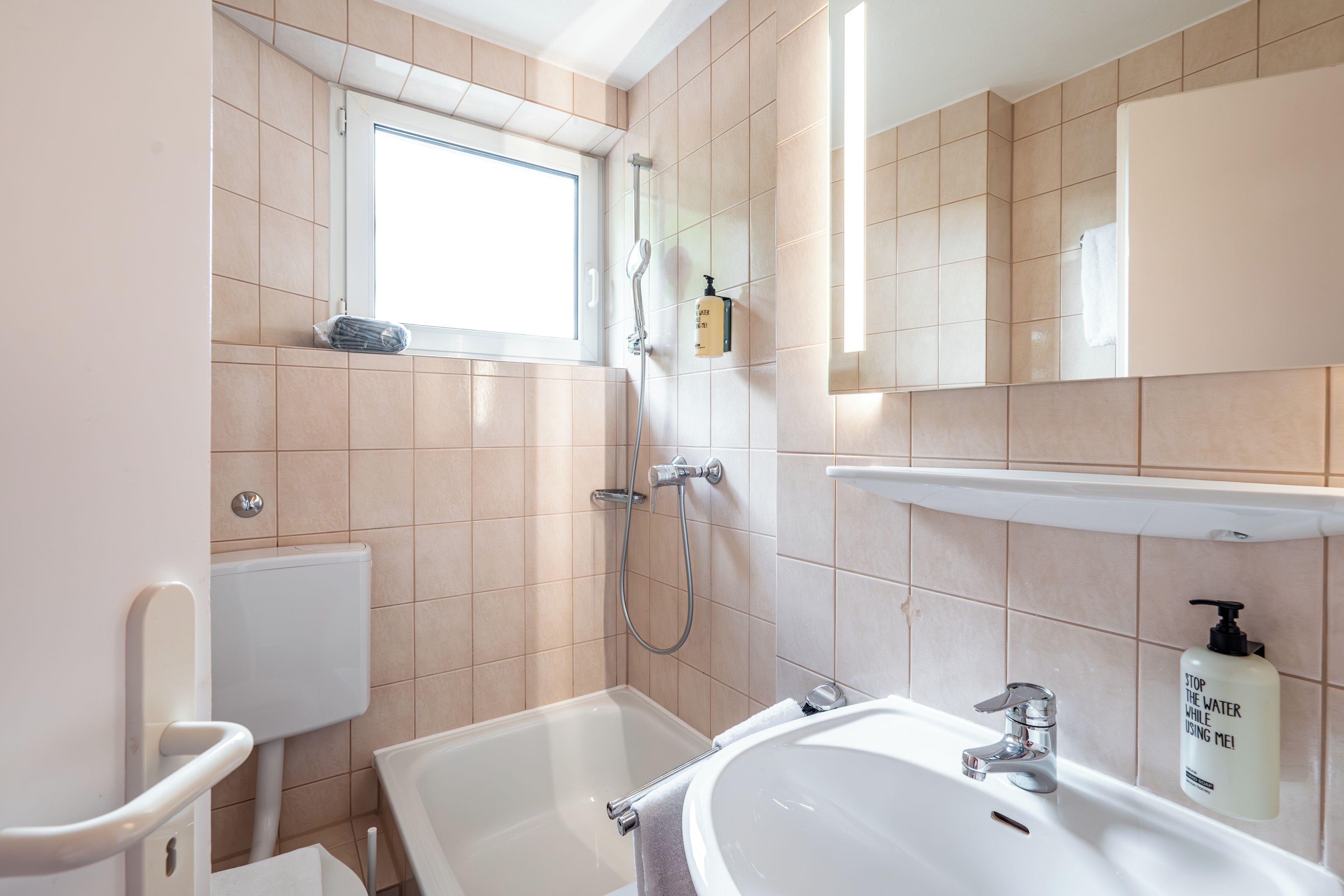 A modern bathroom with a bathtub, a sink, and a shower.