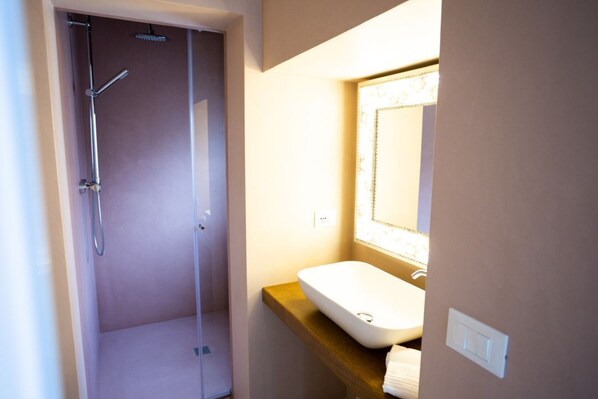 A bathroom with a shower, a sink, and a mirror.