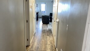A hallway with a carpeted floor, a door on the left, and a window at the end. - The Pearl - Beautiful, renovated Houseboat in Venice Marina!  (Venice)