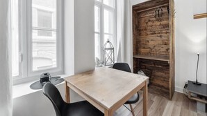A room with a wooden table and chairs, large windows, and a rustic wooden wall with hooks. - INITIAL | MEMORY FACTORY | Centre-Ville de Québec (Québec City)