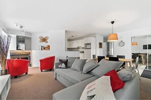 Relax in this stylish living space with a sofa, armchair, and dining area.