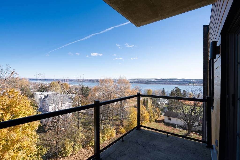 Un balcón con vista despejada a un lago y árboles circundantes.