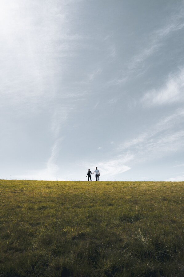 A grassy field with two people walking towards the horizon. - Dog Friendly Shepherd's Hut, Perfect for Couples (Ashford)