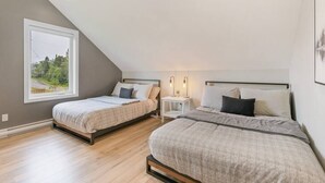 A bedroom with two beds, a window, and a nightstand with lamps. - Initial | Soeur No2 | MSA (Saint-Ferréol-les-Neiges)