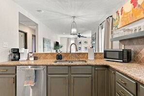 A modern kitchen with a stainless steel refrigerator, a microwave, and a coffee maker.