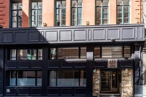 Un immeuble à la façade noire, doté de nombreuses fenêtres et d’une enseigne indiquant qu’il s’agit d’une résidence de la ville.