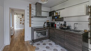 Una cocina moderna con una isla central, electrodomésticos integrados y suelo de madera.