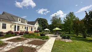 A house with a garden patio, outdoor furniture, and a lawn. - Minutes from Downtown Easton and St. Michaels | Pool | 1st Floor Bedroom | Pet F (Easton)