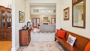 A spacious living area with a wooden sofa, a coffee table, and a dining area in the background. - Minutes from Downtown Easton and St. Michaels | Pool | 1st Floor Bedroom | Pet F (Easton)
