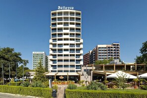 A multi-story hotel with a central tower labeled 'Bellevue,' surrounded by other buildings and a landscaped courtyard.