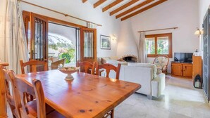 A spacious living area with a wooden dining table, a sofa, and a TV stand. - VILLA FELIZ, beach, pool, wifi, a/a, 10 pax (Moravit)