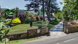 A stone wall entrance to a hotel with a sign indicating it is the Hotel de St. Jean. - Chateau De La Falque (Saint-Geniez-d'Olt-et-d'Aubrac)