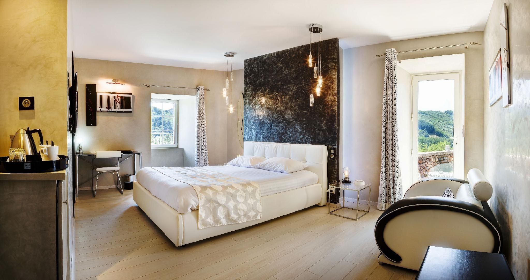 Un dormitorio moderno con una cama grande, un escritorio y vistas al exterior.