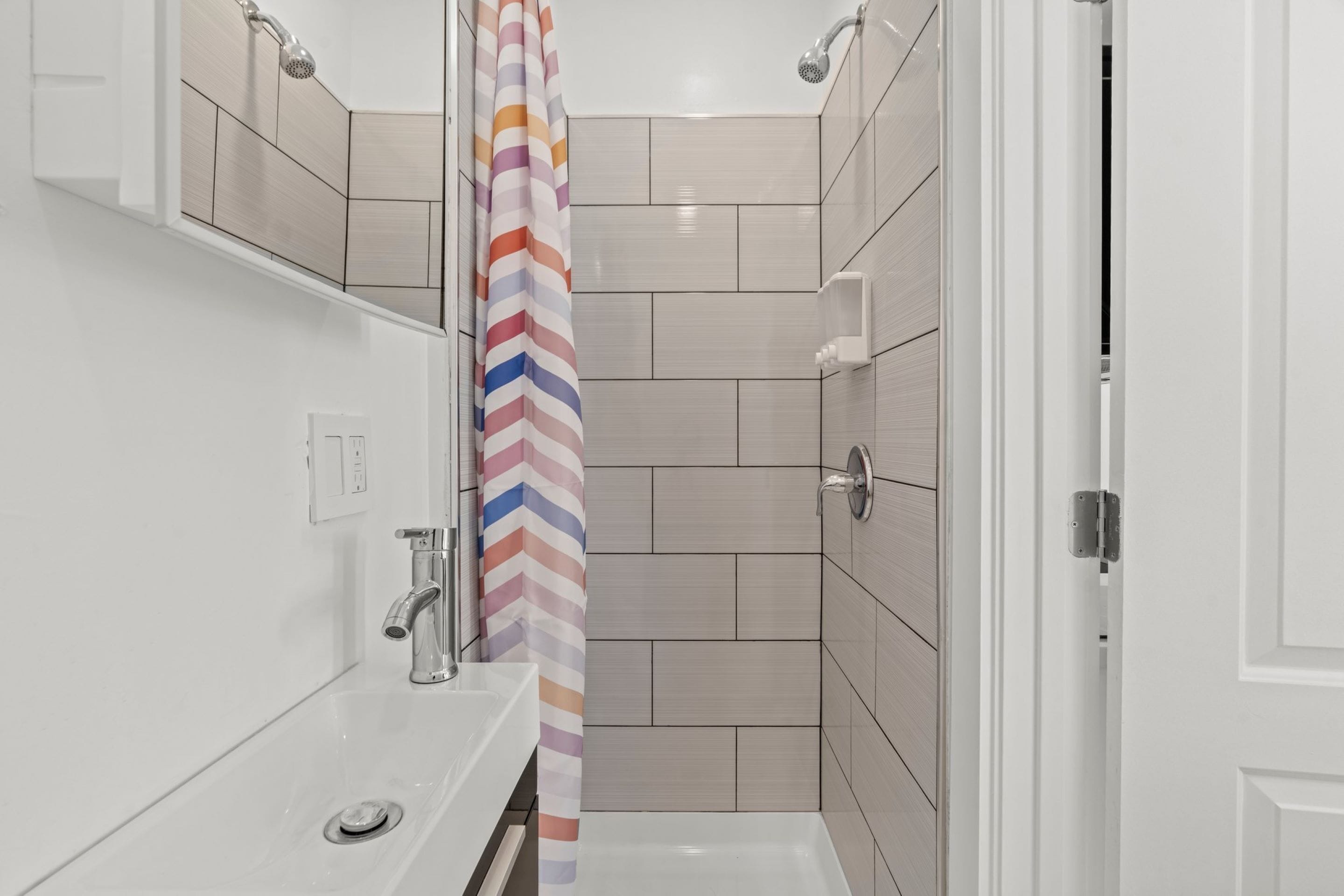 Une salle de bain moderne équipée d’une douche, d’un lavabo et de toilettes.