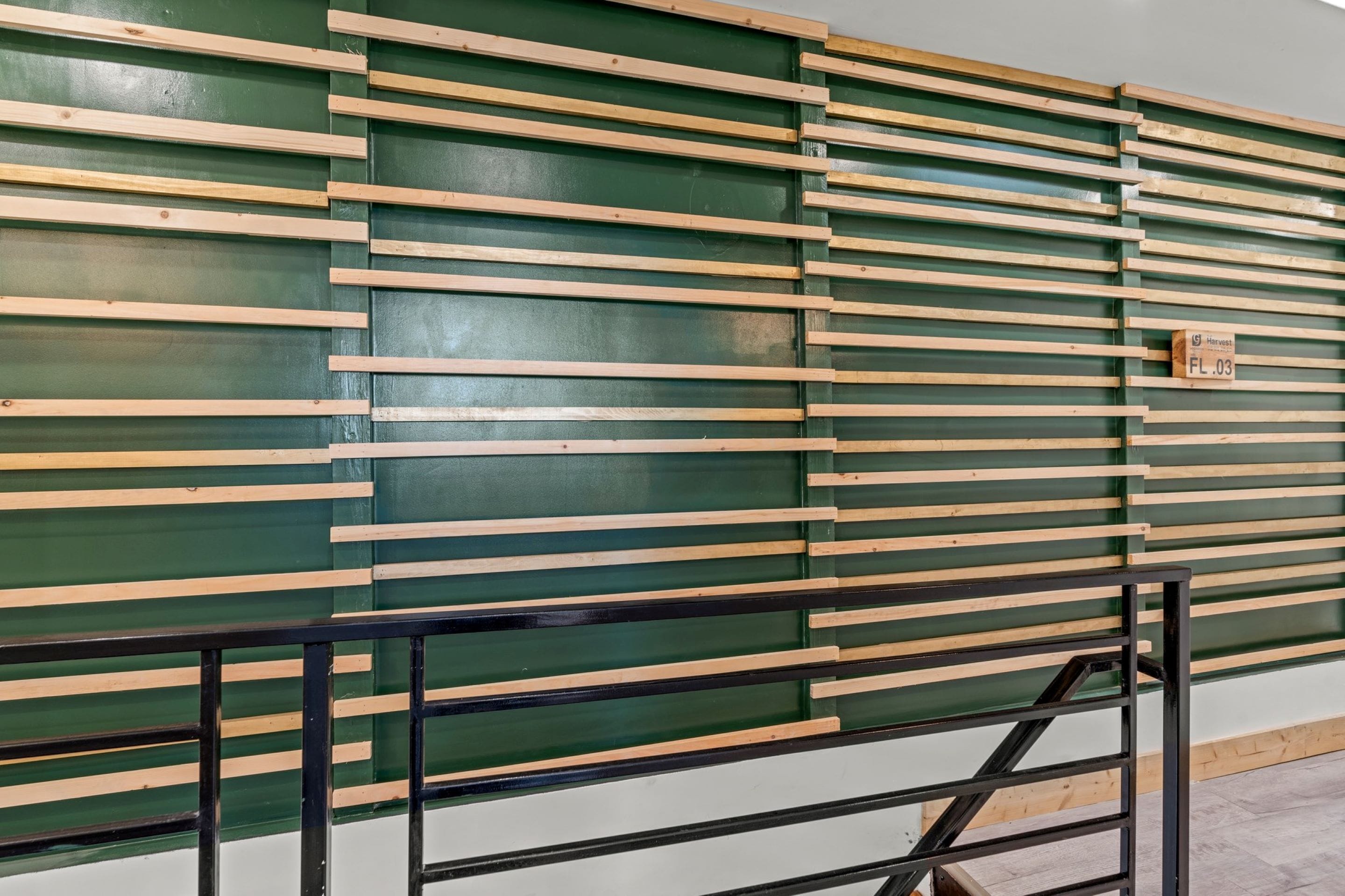 A wall with horizontal wooden slats and a metal gate.