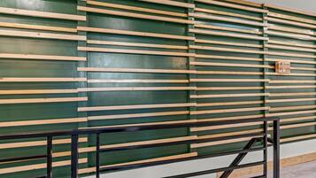 A wall with horizontal wooden slats and a metal gate.