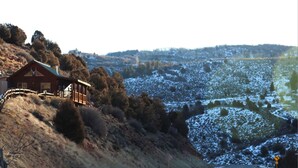 A house with a red roof and a balcony on a hillside.