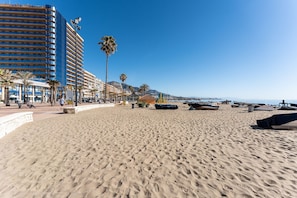 A beach with a hotel named 'HOTEL PARAMAR' in the background, palm trees, and boats on the sand. - MalagaSuite Fuengirola Beach & Sun (Fuengirola)