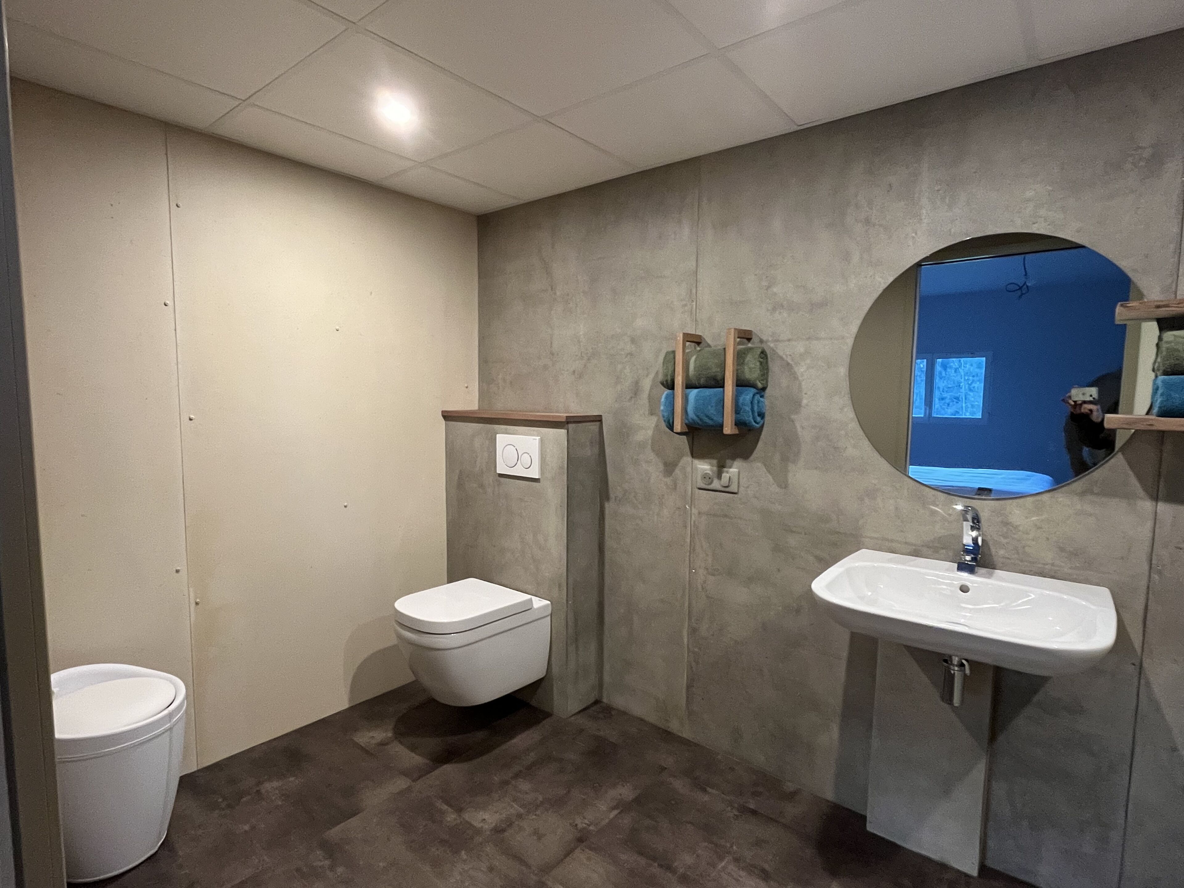 A bathroom with a toilet, sink, and towel rack.