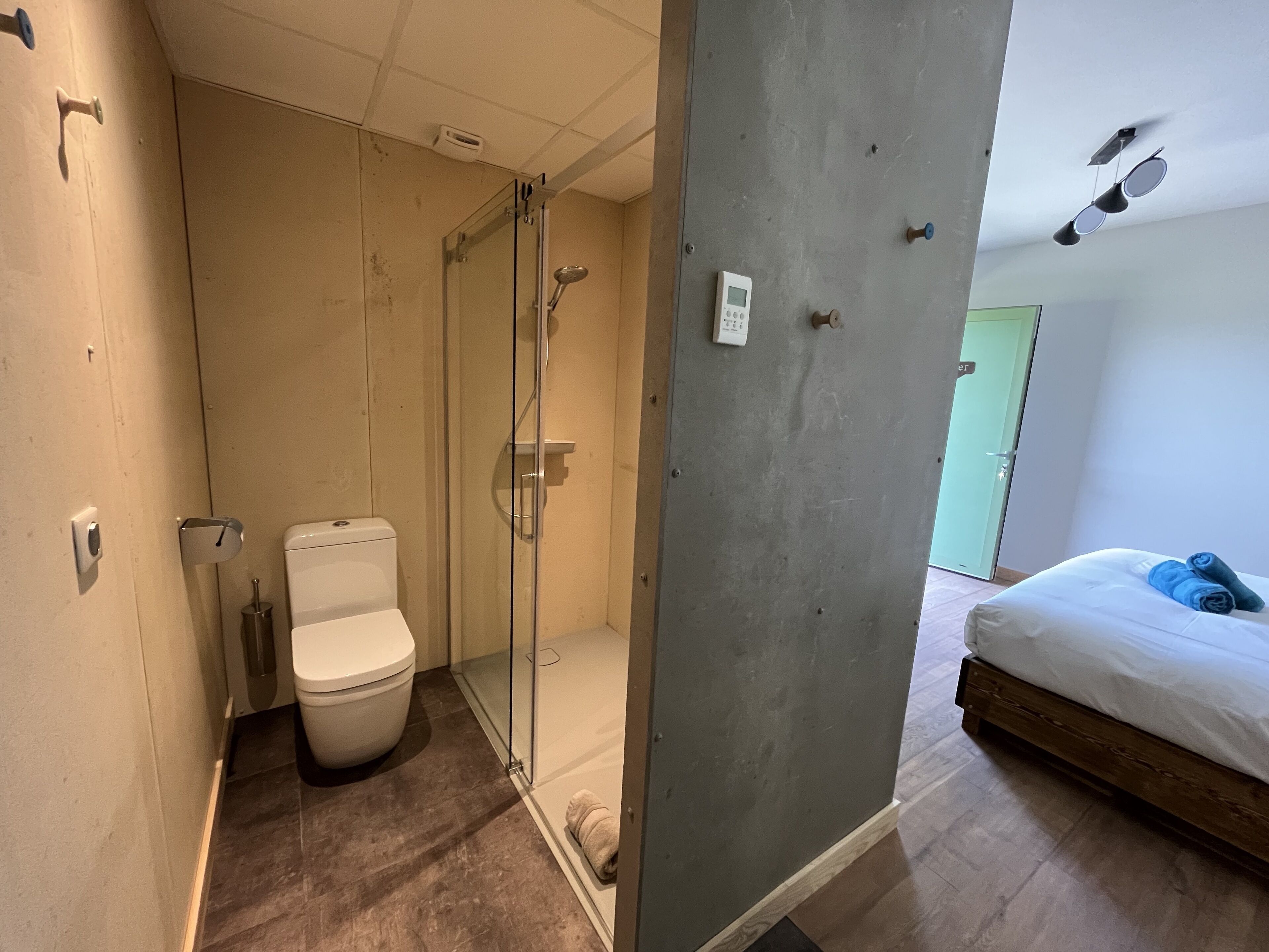 A modern bathroom with a glass-enclosed shower, a toilet, and a sink.