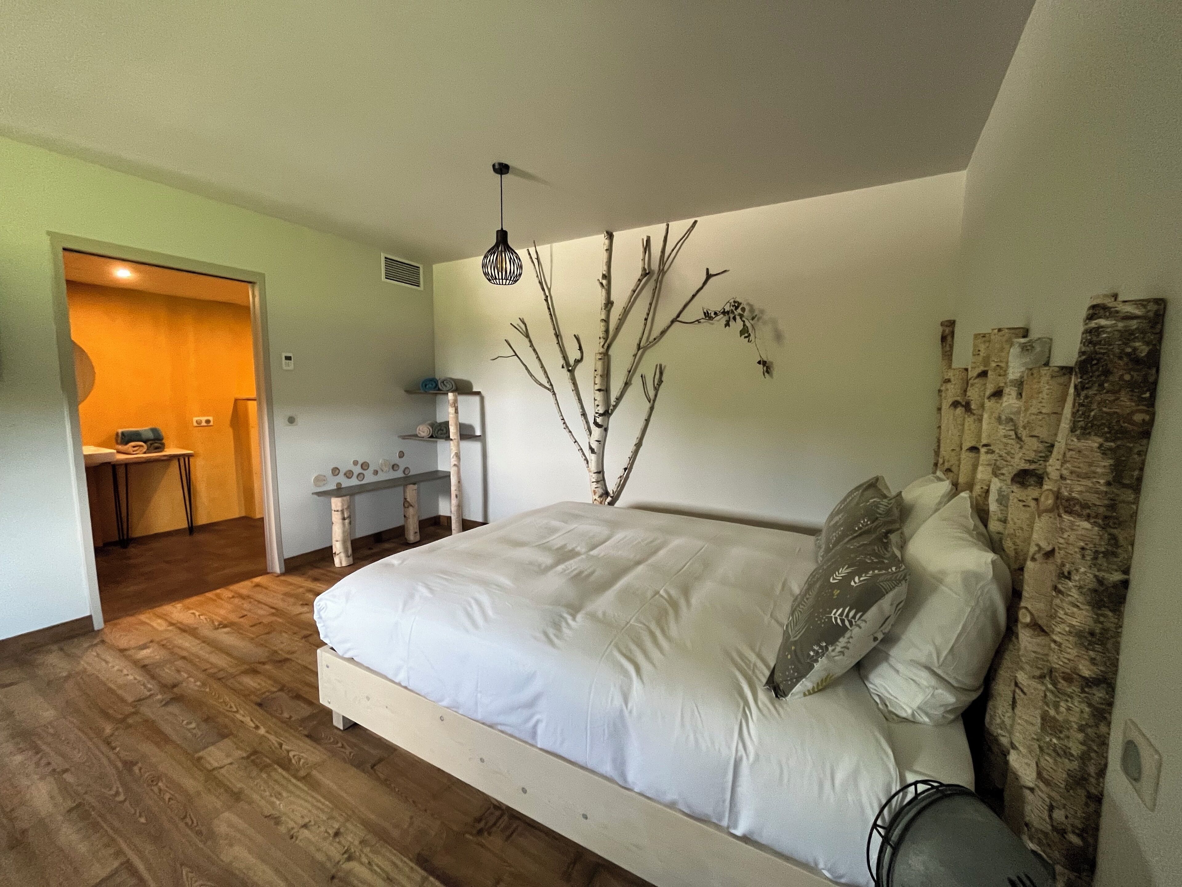 A bedroom with a wooden bed, a desk, and a chair.