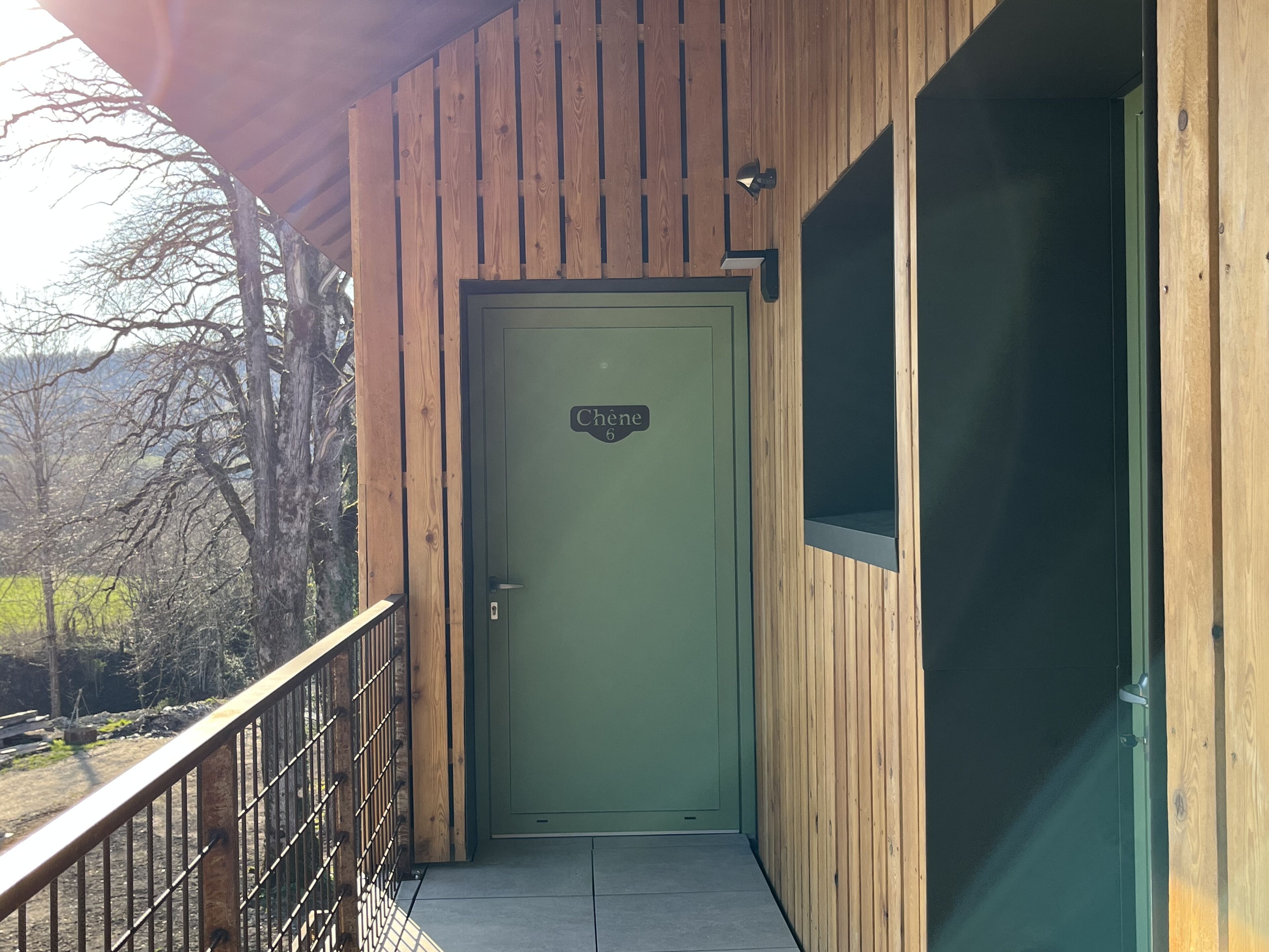 Un edificio de madera con una puerta verde que dice "Chene 6".