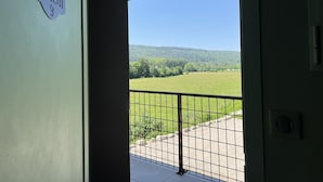 A balcony with a metal railing, a clear view of a green landscape, and a sign reading "Tilleul 9". - Hôtel En Tilleul (Pont-du-Navoy)