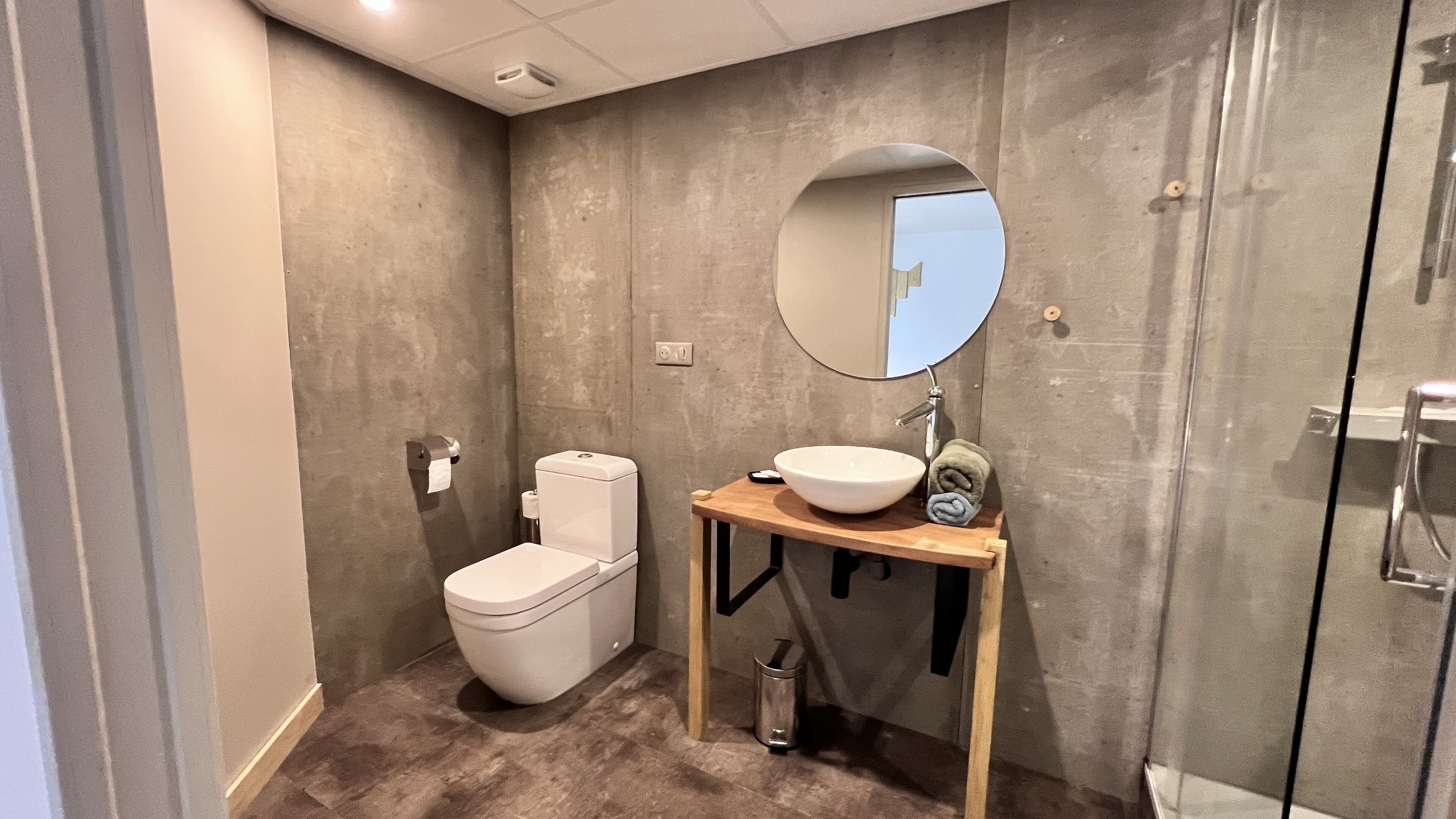 Une salle de bain moderne équipée de toilettes, d’un lavabo et d’un miroir.