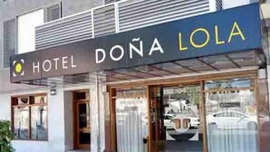 Entrada de un hotel con un cartel que dice "HOTEL DOÑA LOLA".