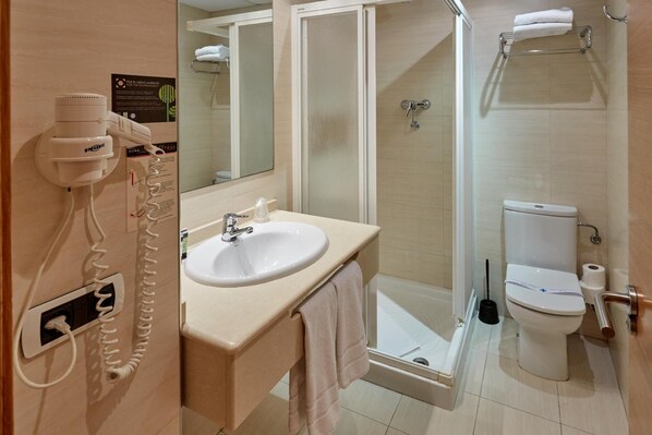 Un baño con lavamanos, inodoro y ducha.