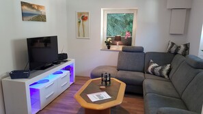 Living area - Chic vacation home, nestled in the beautiful Schleil landscape, equipped with: Baby crib, garden area with play facilities and covered barbecue and smoking area, fly screens and pleated blinds on all windows, flat screen TV, open plan kitchen with... (Taarstedt)