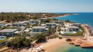 A coastal resort with modern villas, a beach, and a pool area. - One&Only Aesthesis (Glyfada)