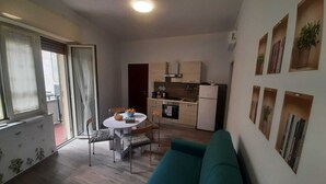 A compact living space with a kitchenette, a dining area, and a sofa.