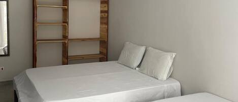 Un dormitorio con cama, un banco y un ventilador de techo.