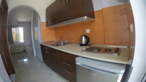 A compact kitchen with a stove, sink, and cabinets. - Yianna Studios (Rhodes)