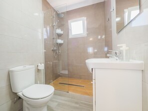 Ein Badezimmer mit Toilette, Dusche und Waschbecken.