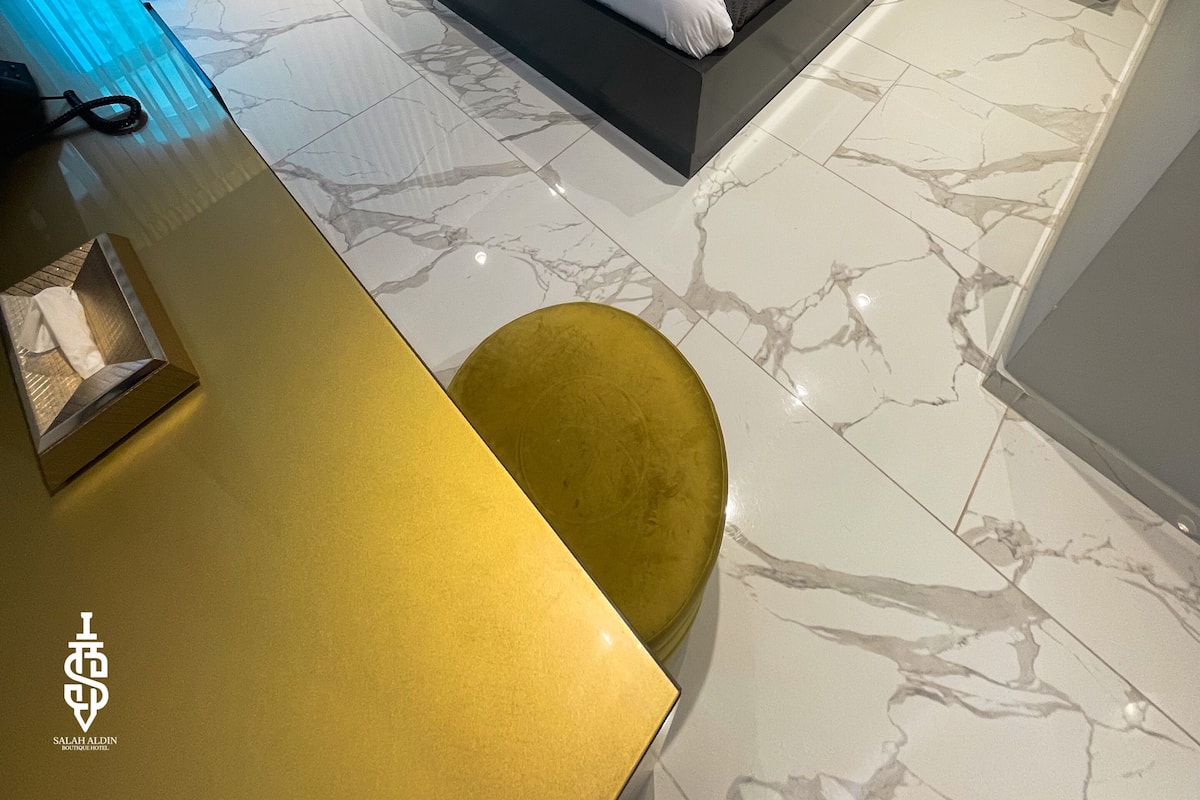 Une chambre à coucher moderne avec un lit, des tables de chevet et un bureau avec une chaise.